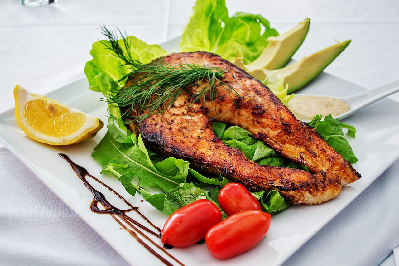 Prato real de salmão grelhado com folhas, tomates, abacate e limão.